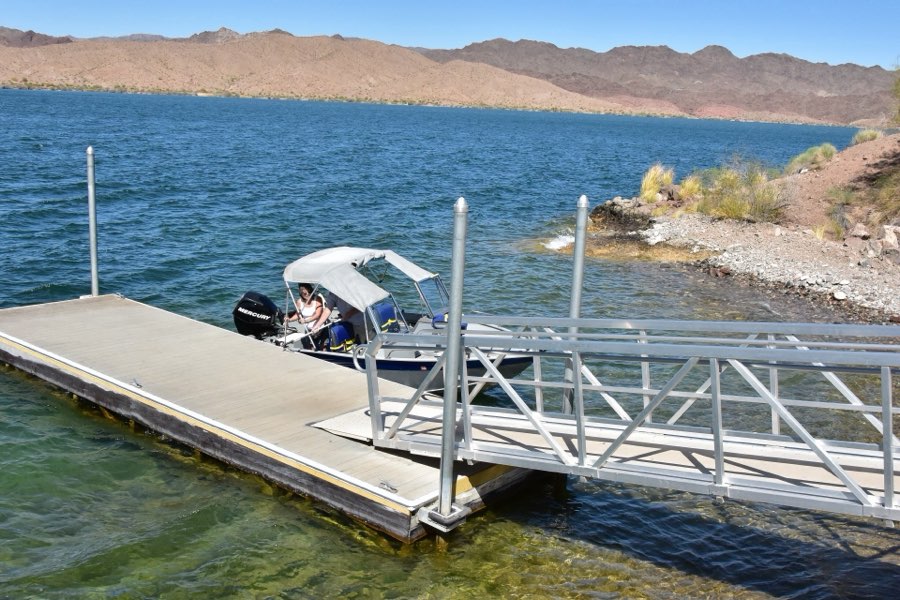A boat at a dock on the clear blue water of Lake Havasu, with desert mountains behind