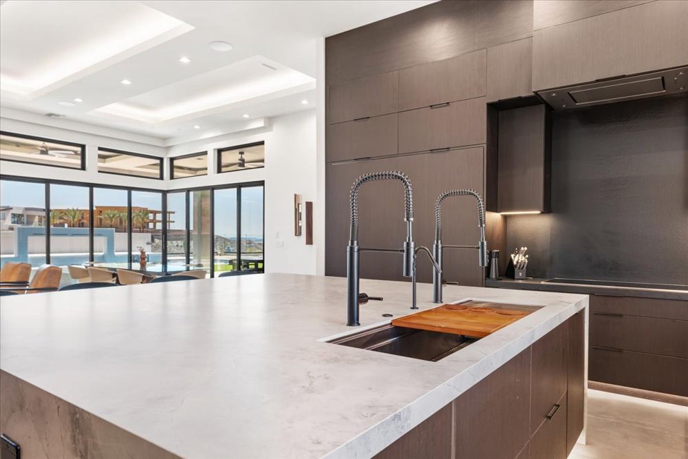 Kitchen island with an oversized workstation sink and dual faucets