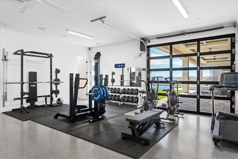 Home gym in the garage with a glass roll-up door