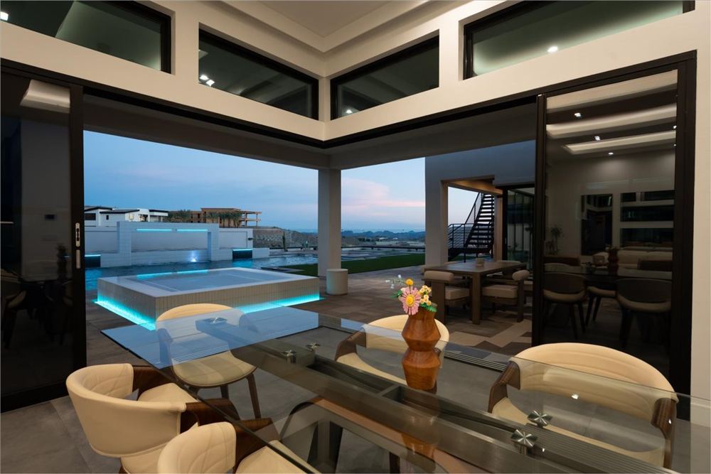 Dining area at twilight opening to the lit spa