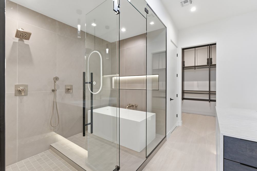 Primary bath glass shower with a soaking tub inside