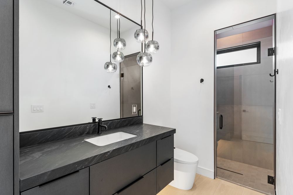 Bathroom with a black stone vanity and walk-in shower