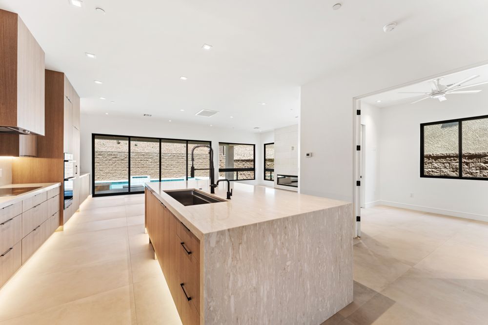Kitchen island with waterfall stone countertop and pool view