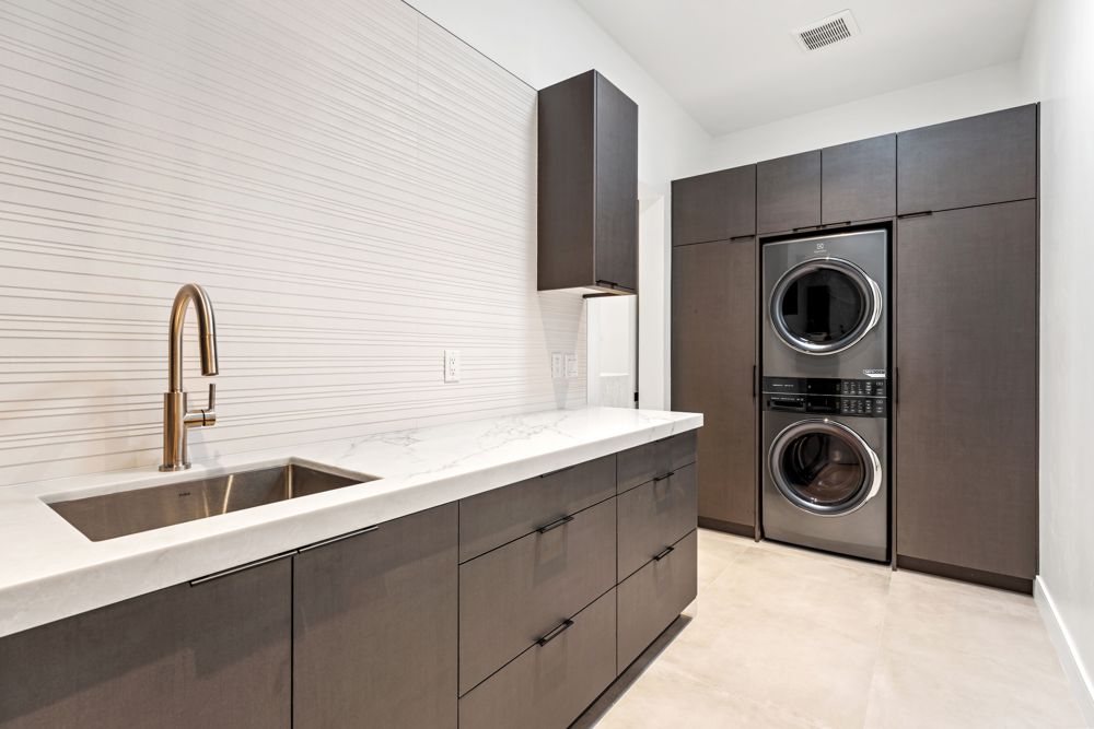 Laundry room with sink and stacked washer and dryer